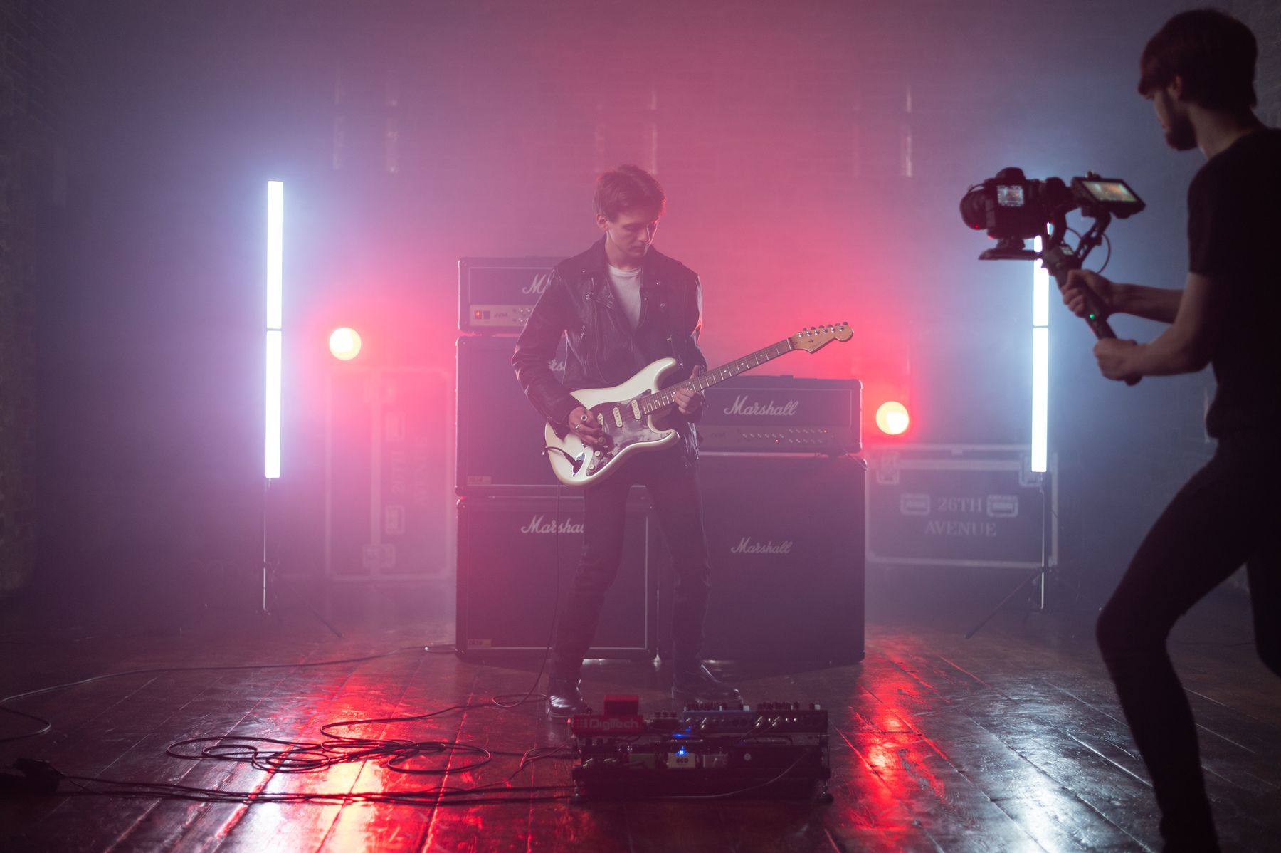Guitarist playing live in front of a full stack